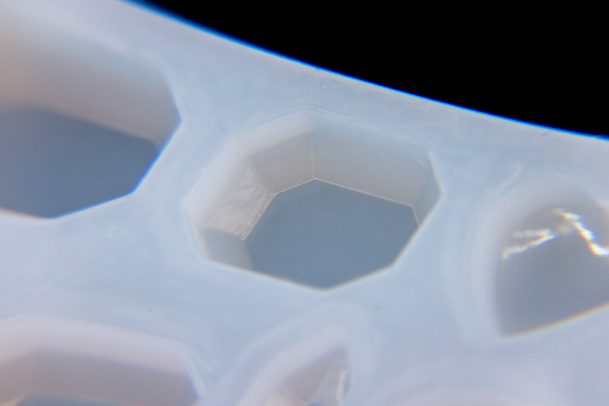 the inside cavity of a silicone mold used for faux gemstones using uv resin